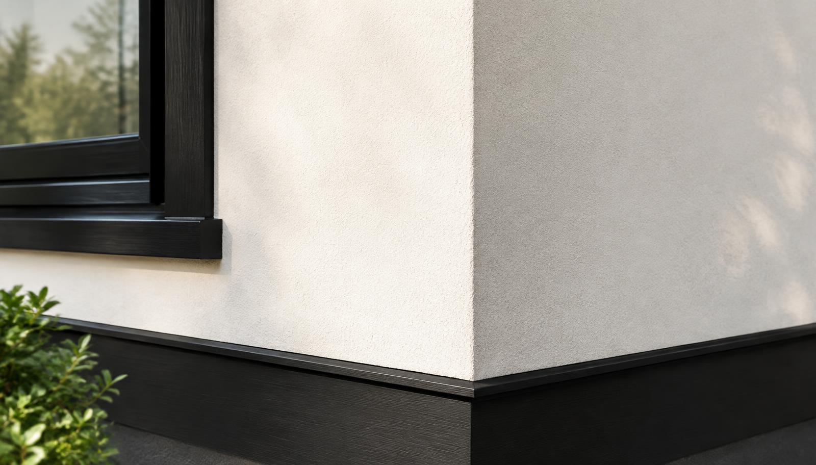 Corner where warm white stucco meets black painted trim