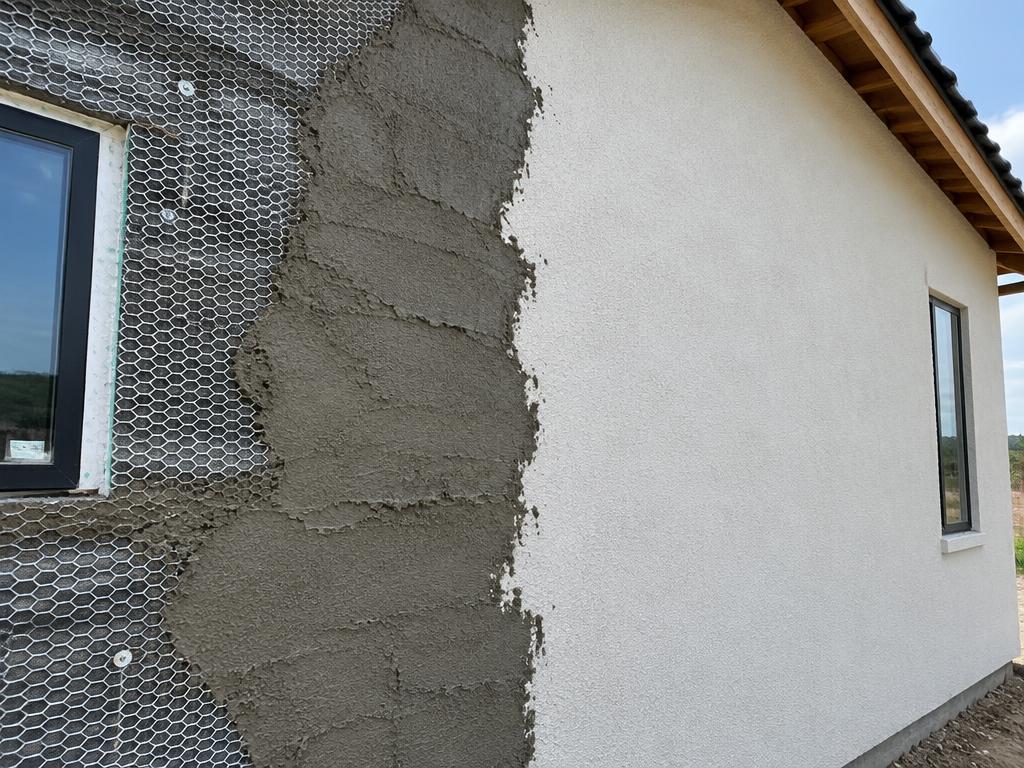 New stucco wall with lath and brown coat on one side and finished stucco on the other